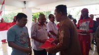 Ketua PD PPMI SPSI Sulut, Aswin Lumintang, saat diberikan bendera Merah Putih oleh Wawali Kota Manado, dr Richard Sualang.